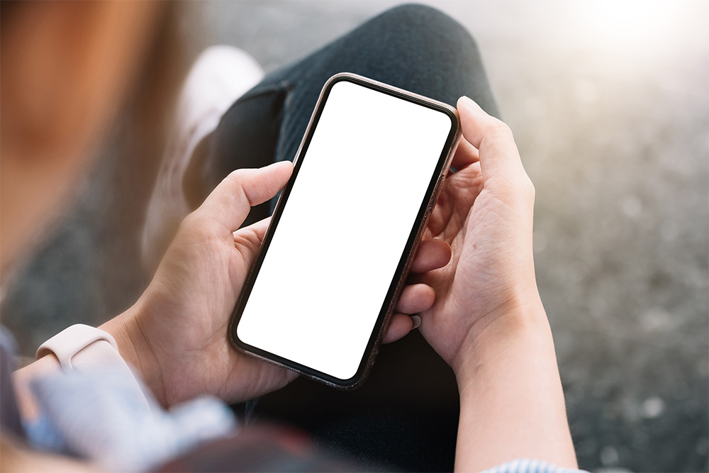 Hände halten Smartphone mit leerem weißen Display